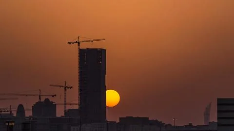 A tower in Doha timelapse, Qatar, under construction, silhouetted against the Stock Photos
