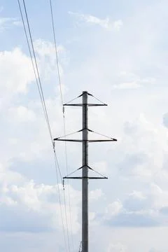 A tower for electrical wires against the background of a blue sky. Stock Photos