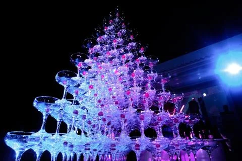 A tower of empty martini glasses with a cherry is on the table. Party at the Stock Photos