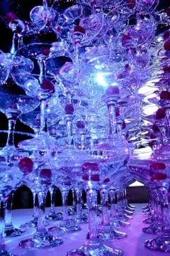 A tower of empty martini glasses with a cherry is on the table. Party at the Stock Photos