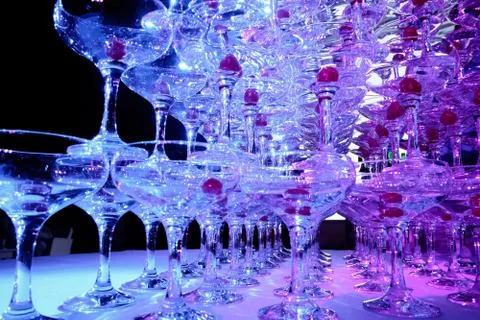 A tower of empty martini glasses with a cherry is on the table. Party at the Stock Photos