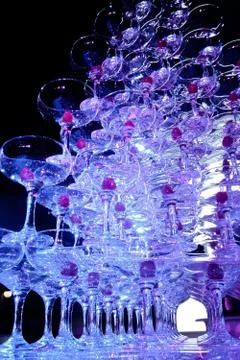 A tower of empty martini glasses with a cherry is on the table. Party at the Stock Photos