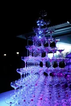 A tower of empty martini glasses with a cherry is on the table. Party at the Stock Photos