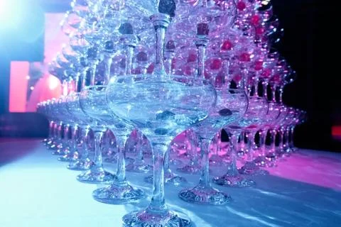 A tower of empty martini glasses with a cherry is on the table. Party at the Stock Photos