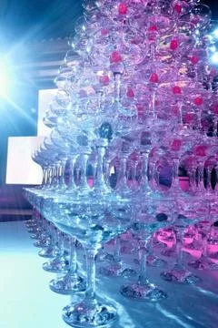A tower of empty martini glasses with a cherry is on the table. Party at the Stock Photos