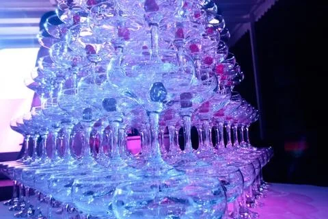 A tower of empty martini glasses with a cherry is on the table. Party at the Stock Photos