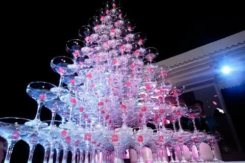 A tower of empty martini glasses with a cherry is on the table. Party at the Stock Photos