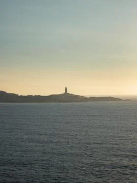 Tower of Hercules, illuminated by the last rays of the sun at sunset. Stock Photos