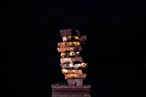 A tower made of assorted chocolate chunks with almonds and hazelnuts on an ou Stock Photos