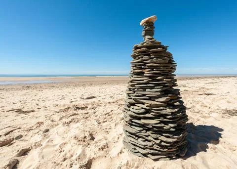 Tower made of flat stones on a sandy beach Stock Photos