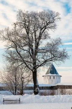 The tower of the monastery, a tree and a bench Stock Photos