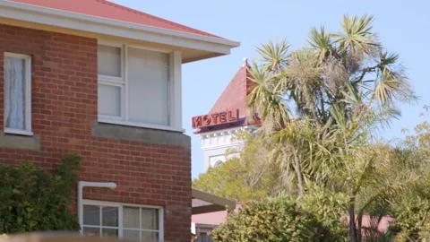 Tower Motel sign seen through residential trees and buildings Stock Footage 306500149