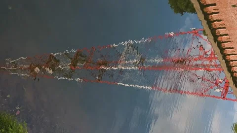 Tower reflected in calm water with slight ripples creating distortions. Vidéo 344527978