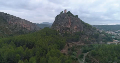 Tower on rocky crag from drone view with cloudy sky Stock Footage 214112129