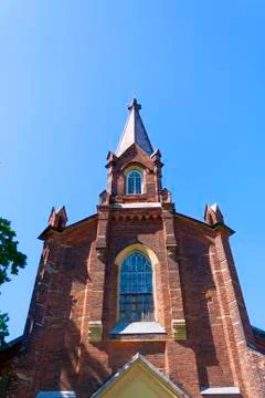 Tower of a small red brick Gothic cathedral Stock Photos
