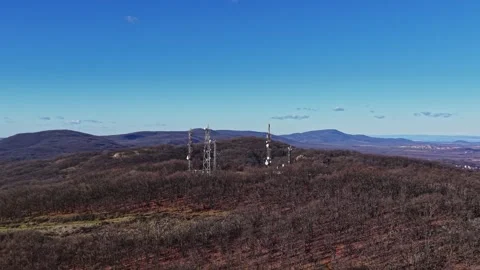 Tower structures stand on a hill under a clear blue sky Stock Footage 335144253