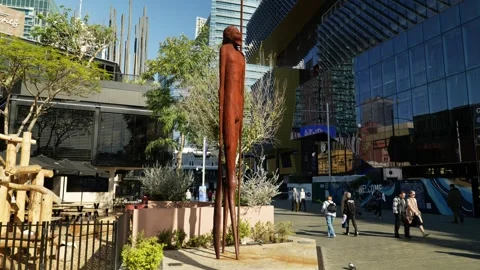 Towering Aboriginal man statue and Perth pedestrians 6K Stock Footage 311986080