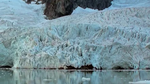 Towering Arctic Ice Wall Cradled by the Shimmering Polar Sea 스톡 동영상 344625131