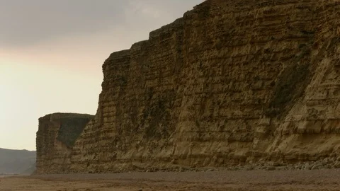 Towering cliff above beach and sea - 3 different shots Stock Footage 105320792