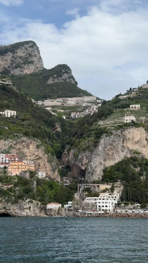 Towering cliffs and cliffside villas on the Amalfi Coast seen from a ferry  Stock Footage 332975704