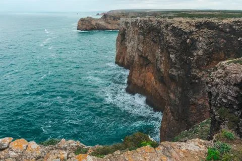 Towering cliffs and rugged ocean stacks rise from turquoise waters under a .. Foto stock