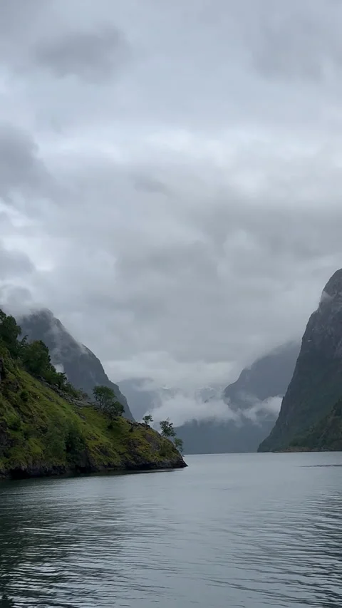Towering cliffs emerging from misty waters in Norway Stock-Footage 314072751