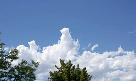 Towering Cloud Rising Into a Clear Blue Sky Foto stock