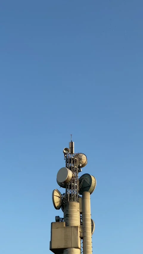 A towering communication tower stands tall against a clear blue sky Stock Footage 316839874