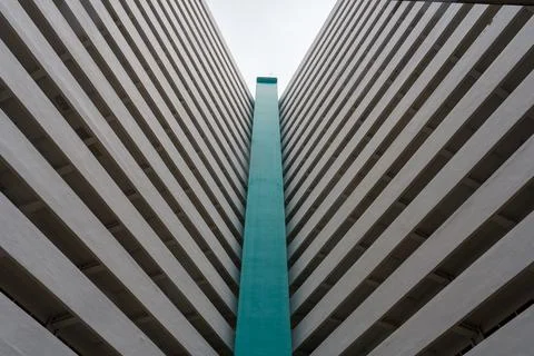 Towering concrete structures meet at a bright teal vertical stripe Stock Photos