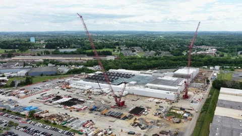 Towering construction cranes loom over sprawling data center build site Stock Footage 337978008