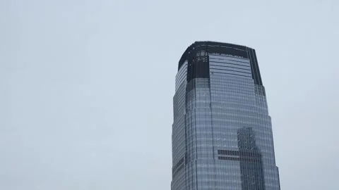 A towering corporate skyscraper stands prominently against a backdrop of a 스톡 동영상 295072012