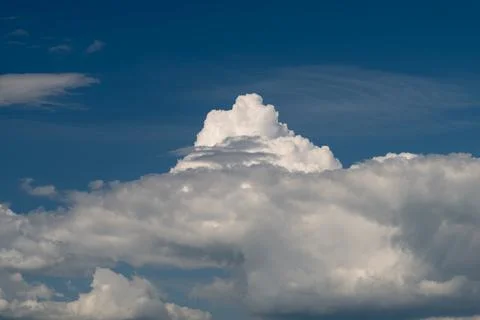 Towering cumulus cloud against deep blue sky Photos