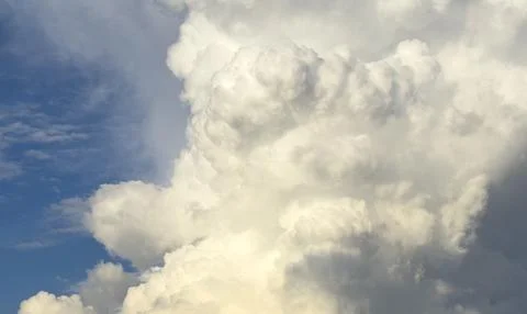Towering cumulus cloud rises against blue sky in daylight. Large formation .. 스톡 사진