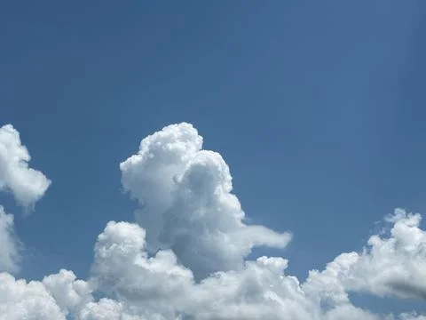 Towering Cumulus Cloud Rising in Bright Blue Sky Фото