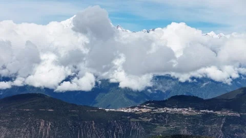 Towering cumulus cloud wall above mountain valley and village in China Stock Footage 341842399