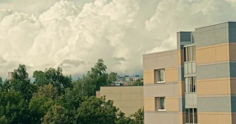 Towering cumulus clouds above apartment building with trees in urban Video stock 340997405
