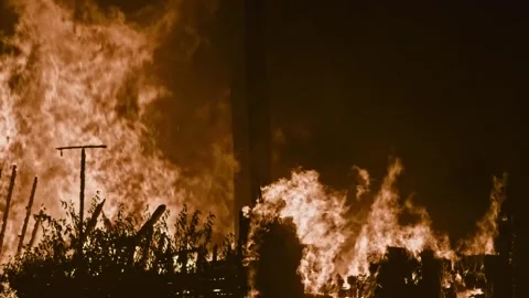 Towering Flames Devour Wooden Structure at Night Stock Footage 313123968