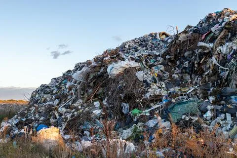 A towering heap of mixed refuse extends towards the horizon, illustrating m.. Фото