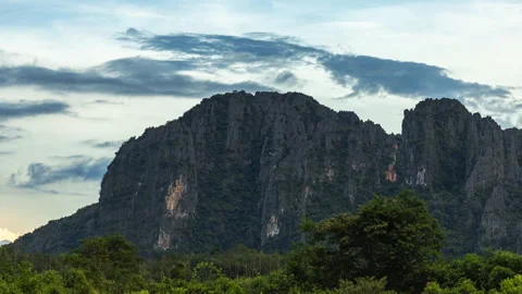 Towering limestone karst mountains lush tropical forest cloudy sky natural Stock Footage 317442416