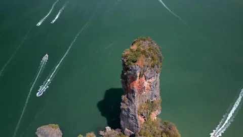 Towering limestone sea stack surrounded by speedboats in Krabi, Thailand. Aerial Video stock 341081505