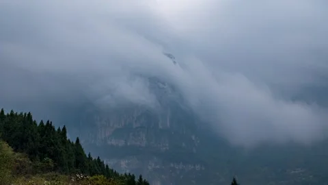 Towering mountains surrounded by clouds on an overcast day. Stock Footage 330444991