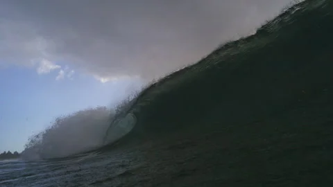 Towering Ocean Wave Curling Beneath Dark Clouds Near Water Surface Stock Footage 344388668
