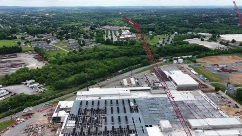 Towering red cranes rise above unfinished data center roof, construction Stock Footage 337994302