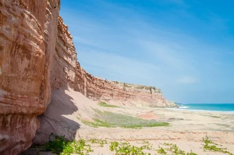 Towering red sandstone cliffs at Angola's coast line Stock Photos