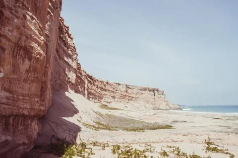Towering red sandstone cliffs at Angola's coast line in the Namib Desert Stock Photos