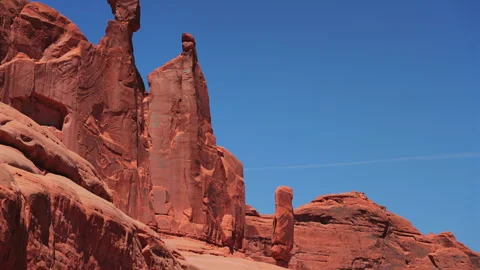 Towering Red Sandstone Spires Against Clear Blue Sky in Arches National Park. 動画素材 342490209