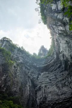 Towering rock faces frame a narrow sky gap Stock Photos