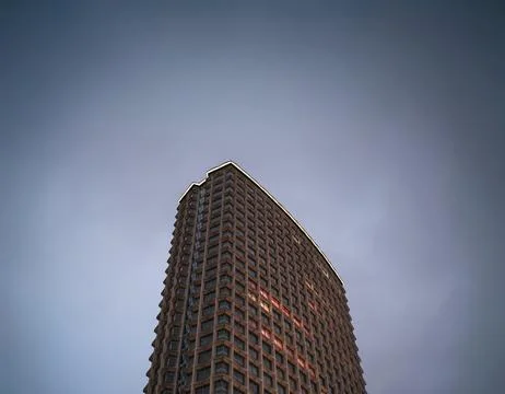 Towering Skyscraper Against Overcast Sky Stock Photos