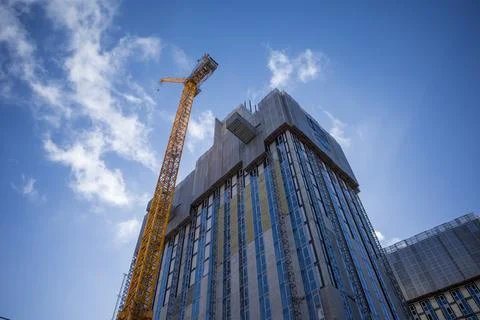 Towering skyscraper under construction against a vivid blue sky. Manchester.. 스톡 사진