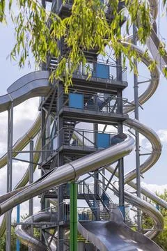 A towering slide section features multiple twisting slides made of shiny me.. Foto stock
